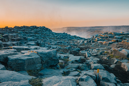 Magnificent rock formations in the Dettifoss area in Iceland during summer sunset, blue rock surrounded by beautiful orange light on the sky.の写真素材