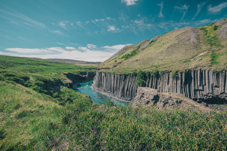 Overview of Studlagil canyon in Iceland, picturesque valley with basalt columns standing high on a...