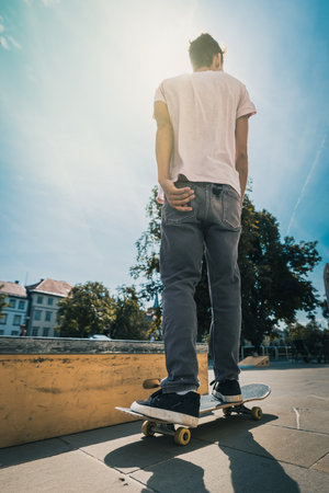 young skateboarder riding on skateboard at skatepark in cityの写真素材