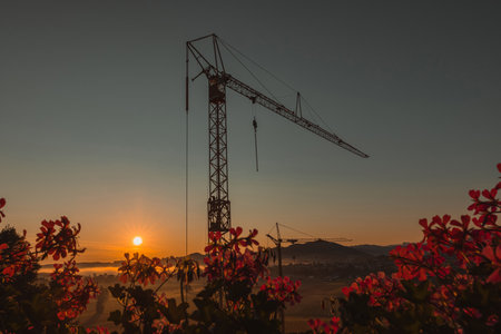 Construction site of an apartment building in early morning with sunrise, visible mist and fog on the fields. Epic modern photo of construction site.の写真素材