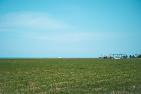 Small field airport at the city of Puerto Limon on carribbean side of Costa Rica. View across the field towards a small departure building and other areasの写真素材
