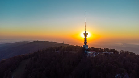 Early morning sunrise panorama of Sljeme above Zagreb with visible antenna tower, big massive hill and layers of fog below in valley. Epic panorama above zagrebの写真素材