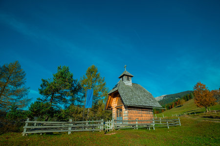 Small chapel or church on the plateau of Uskovnica, pilgrimage church in the green meadows, surrounded by brown trees in autumn.の写真素材