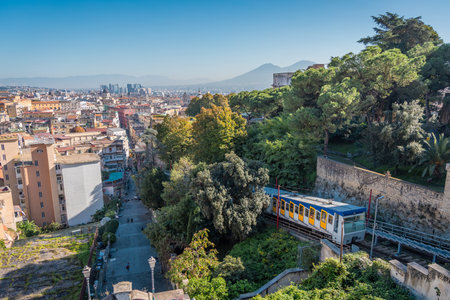 Funicular riding from the lower part of the napoli city towards the saint elmo fortress above the ground. Visible panorama of the napoli city with the white and blue funicularの写真素材