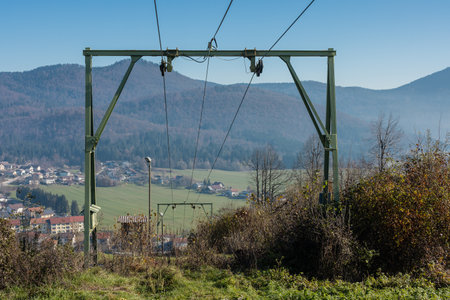 View of ski lift in autumn, stopped, on a ski slope Ulaka above Stari trg pri Lozu, Slovenia. Visible ropes, upper station and green grass.の写真素材