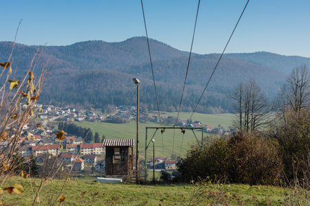 View of ski lift in autumn, stopped, on a ski slope Ulaka above Stari trg pri Lozu, Slovenia. Visible ropes, upper station and green grass...の写真素材