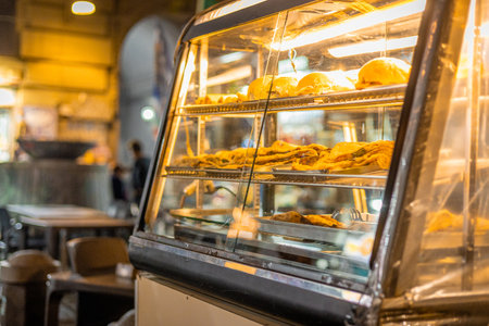 Different Neapoletan treats such as pizza, tramezzini, sandwiches, are resting in a glass dispenser or window on the street corner.の写真素材