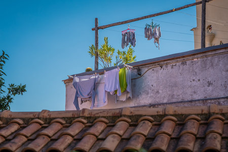 Drying clothes on a balcony on top of the building in Naples, Italy. Typical drying of clothes above rooftops in italian city of Napoli, warm autumn sun takes care of drying..の写真素材