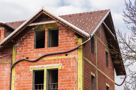 House without facade. Visible red bricks, concrete crossbeams and external drainage. Roof already newの写真素材