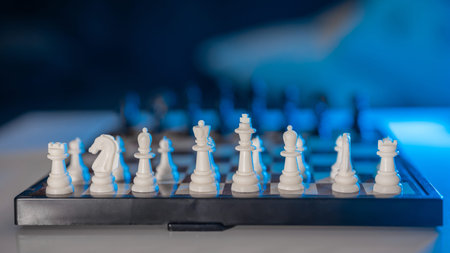 Chess game and board. Two rows of black and white figures of chess game at the beginning. Blue and...