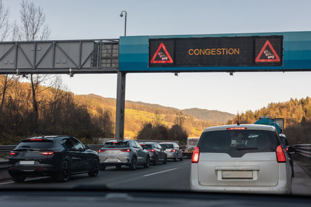 Traffic congestion or jam on Trojane motorway in Slovenia, with rows of cars forming an emergency lane. Visible overhead LED board with sign congestionの写真素材