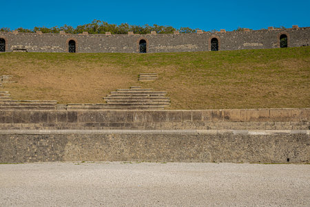 Side view of amphitheatre in pompeii. Collossal view of anfiteatro between the ruins of pompei city close to Naples in italy on a sunny autumn dayの写真素材