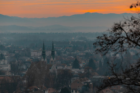 Evening panorama of Trnovo, suburb of ljubljana, with visible famous church and residental blocks. Sun just setting down in winter haze..の写真素材