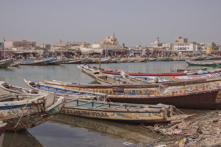 Fishing boats parked on the shore in Saint Louis, a city in northern Senegal. Colorful boats, called pirogues are waiting in a canal of Senegal river.の写真素材