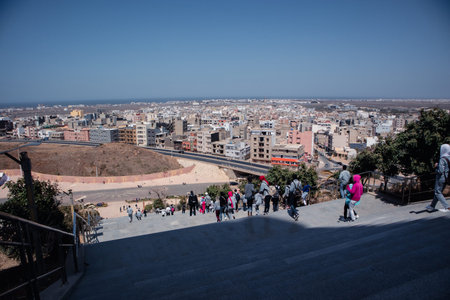 People descending from a monument on a sunny February day in Dakar, Senegal. View from the bottom of...