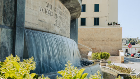Waterfall at Square with monument in the centre of Brindisi, Puglia, Italy, on a warm summer day.の写真素材