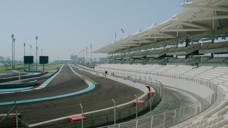 Curve and grand stand of a racetrack curve on the exit and big place for spectators.on a sunny day in abu dhabi.の写真素材