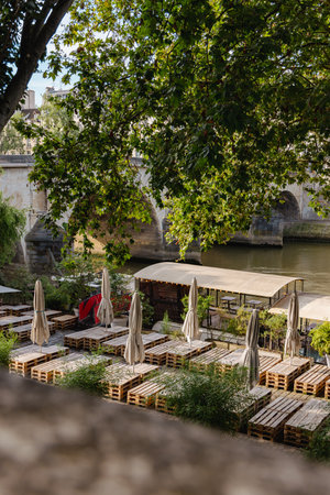 Bars next to the seine river in paris, view of a closed bar with no people, seats and tables made from wooden europalettes.の写真素材