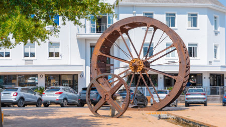 Rusty steel water wheel used to power grain mill on a display in center of Stellenbosch, south africa in the main city square. Sunny day.の写真素材