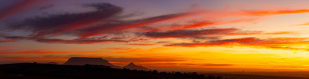 Colorful wide panorama of Table Mountain close to Cape town, south africa. Evening colors and sunset, majestic clouds over the famous flat mountain close to southern capeの写真素材