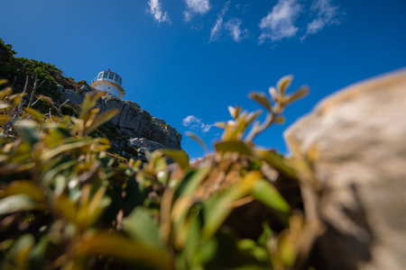 Frontal view of an epic lighthouse at cape point or cape of good hope. Frog view on a hot summer day, no people, blue skies. Lighthouse in africa, view from below.の写真素材