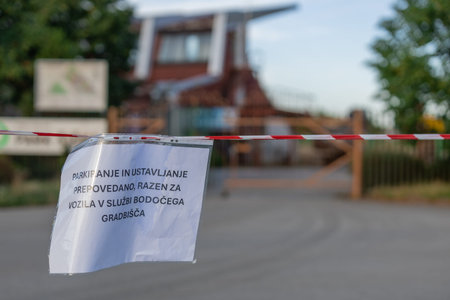 Pribted sign in slovenian prohibiting parking of cars on this parking spot around future athletic...