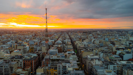 Bari at dusk with a panoramic view of the historic center, bustling port, and calm Adriatic Sea under dramatic clouds and soft sunset light.の写真素材