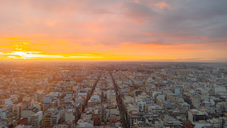 Bari at dusk with a panoramic view of the historic center, bustling port, and calm Adriatic Sea under dramatic clouds and soft sunset light.の写真素材