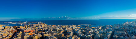 A vibrant aerial panorama of Bari, Italy, capturing the golden-hued Old Town and port alongside the modern city grid, stretching out to the deep blue Adriatic horizon.の写真素材