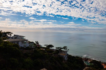Panoramic view of Simons Town, South Africa: colorful coastal houses nestled along a curving...