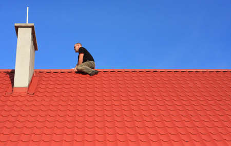Young man sitting on a roofの写真素材