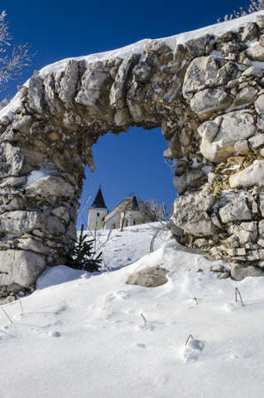 Through ruin view on St  Ursula church on top of the Plesivec mountain, highest elevation church in Slovenia at 1696m above sea level の写真素材