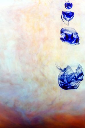 Blue ink in colored water on white background 