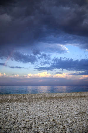 View from beach on a changing weather with rainbow.の写真素材