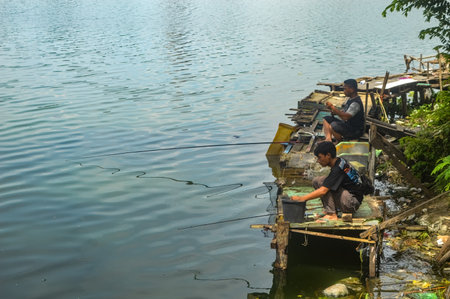 two people were fishing on the edge of the lake, Indonesia, 5 February 2024のeditorial素材
