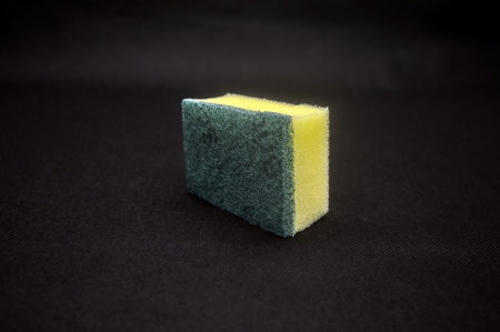 a dishwashing sponge isolated on black background