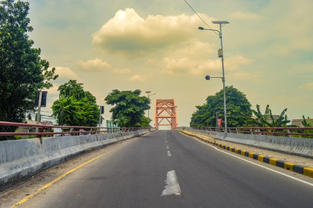 a concrete arch bridge with no vehicles photographed from the middle of the highwayの写真素材