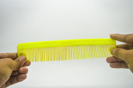 both hands holding a hair comb isolated on white background