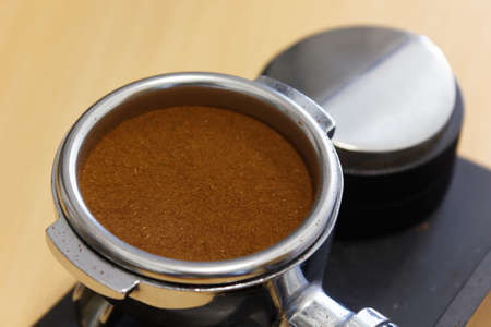 Ground coffee tamped in portafilter and coffee levelerの写真素材