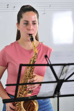 Young student studies lesson on sheet music in the classroom.の写真素材