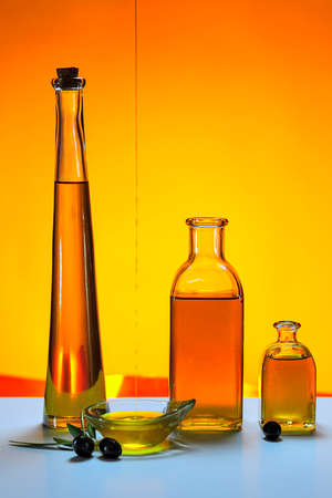 Bottles of virgin olive oil, with colored background.の写真素材