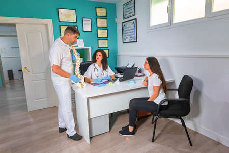 Doctor and nurse attend to patient in consultationの写真素材