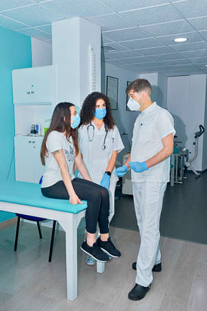 Doctor and nurse attend to patient in consultationの写真素材