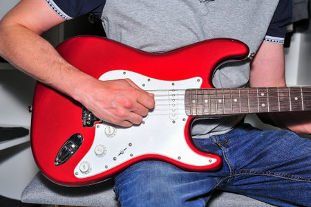 Young man playing electric guitar.