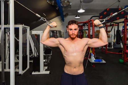 Young boy training his biceps in the gym.