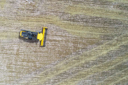 Photo of combine harvester that is harvesting wheat with dust straw in the air.の写真素材