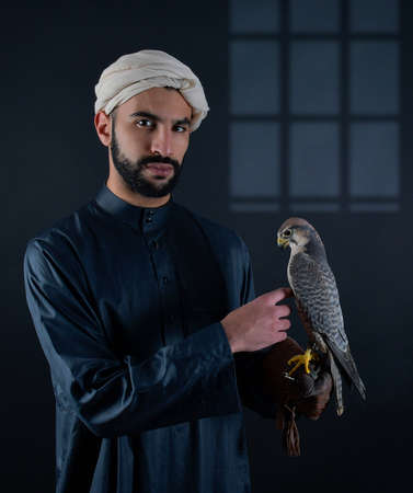 Young falconer holding a bird of prey.の写真素材