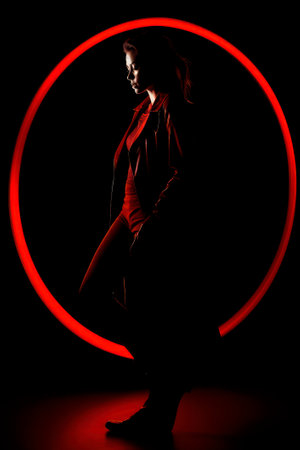 Silhouette of a woman in black, on a red circle backgroundの素材