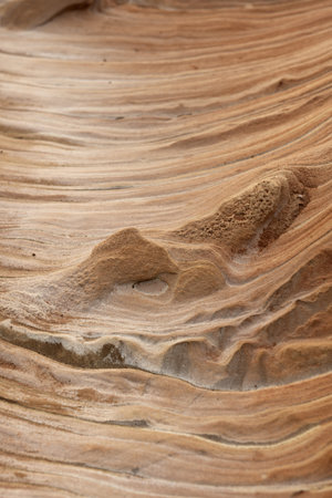 Close-up of intricate sandstone swirls and erosion patterns, highlighting the natural beauty and texture of sedimentary rock formations. Perfect for geological themes and backgrounds.の写真素材