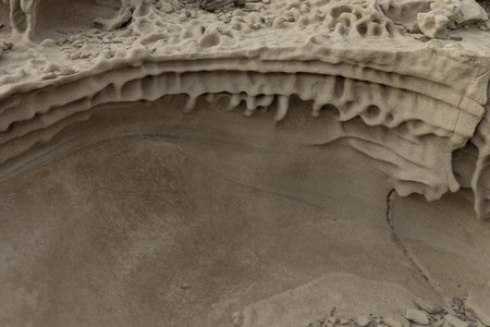 Close-up of sandstone rocks showcasing detailed honeycomb weathering patterns and natural textures. Ideal for geological studies and nature themes.の写真素材